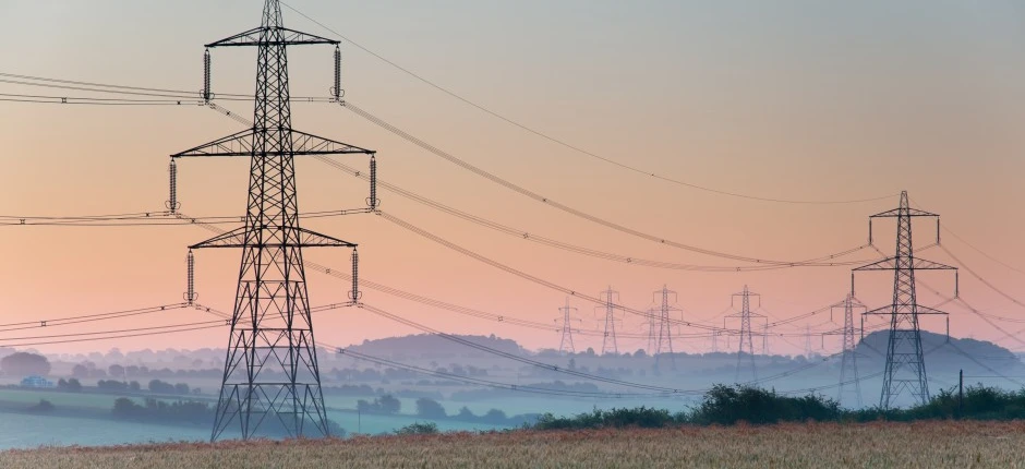 Wieża przesyłowa z liniami napowietrznymi w obszarze wiejskim, dostarczająca energię elektryczną poprzez sieć elektroenergetyczną. Podstawowa infrastruktura publicznej użyteczności.