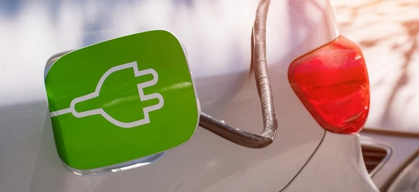 Symbol ładowania samochodu elektrycznego na drzwiach samochodu podkowy z symbolami euro wskazującymi koszt ładowania.