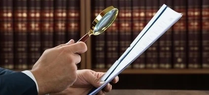 Pracownik umysłowy korzystający z lupki do badania dokumentu. Artykuły biurowe i sprzęt w tle. SEO: Osoba prowadząca biznes korzystająca z lupki w ustawieniu biurowym.