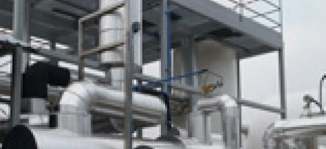 Zbliżenie rur metalowych produkowanych przez maszynę w przemyśle, wykonanych z materiałów kompozytowych. Widoczne są rury obudowy z żelaza i stali, prezentujące zaangażowane procesy inżynieryjne.