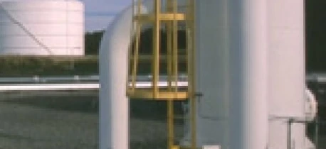 Rura metalowa połączona z zbiornikiem w ustawieniu przemysłowym. Inżynieria oraz maszyny pracujące z materiałami kompozytowymi.