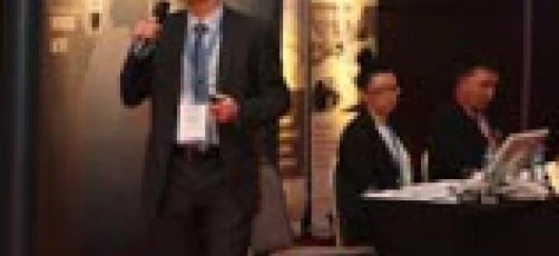 Grupa elegancko ubranych pracowników biurowych w garniturach i spodniach na formalnym wydarzeniu, z technologią w tle. Reklama odzieży męskiej na galę.