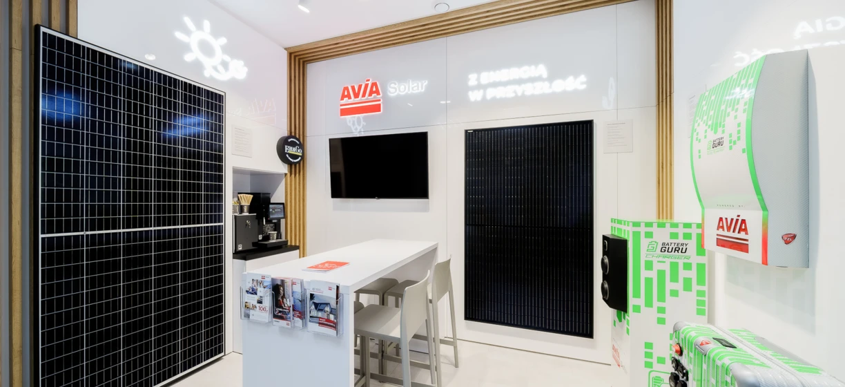 Projekt wnętrza obejmujący eleganckie urządzenie elektroniczne z technologią podświetlenia LED w technologii LCD. Pod telewizorem LCD stoi fotel wyświetlający różne loga marek.