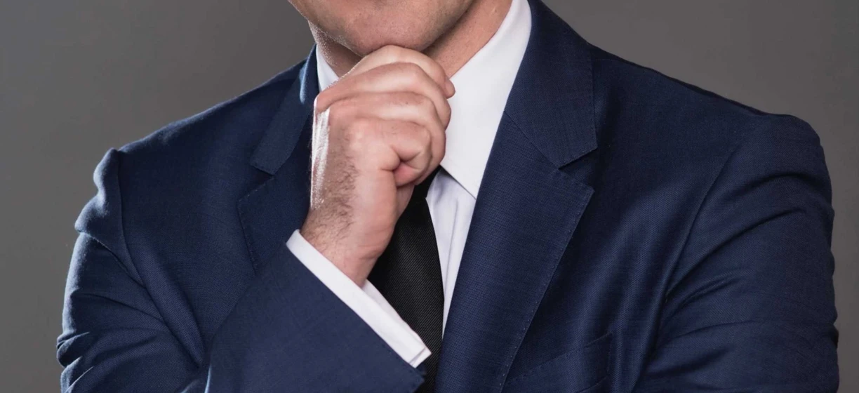 Osoba nosząca okulary i formalną białą koszulę z kołnierzykiem, z widoczną brodą i brwiami. Dbanie o wzrok jest ważne dla dobrego wzroku.