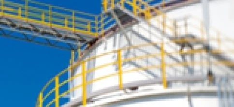 Zbiornik na metal w fabryce przemysłowej, wykonany z materiału kompozytowego i stalowych cylindrów. Inżynieria ekspertów dla efektywnych rozwiązań magazynowania.