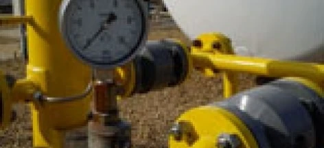 Maszyna przemysłowa z rurą, cylindrem i zbiornikiem magazynowym z zaworami i armaturą hydraulikną wykonaną ze stali. Wykonywane są pomiary na urządzeniu.