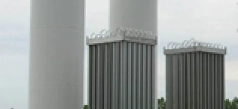 Zbiornik magazynowy w postaci stalowego cylindra wykonany z materiału kompozytowego w przemysłowym otoczeniu. Koncepcja inżynierii i przemysłu z silosem stalowym i aluminiowym.