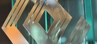 Nowoczesny projekt graficzny ze szkła i metalu o uderzającej symetrii. Wyposażony w eleganckie wykończenie z aluminium i śmiałą typografię.