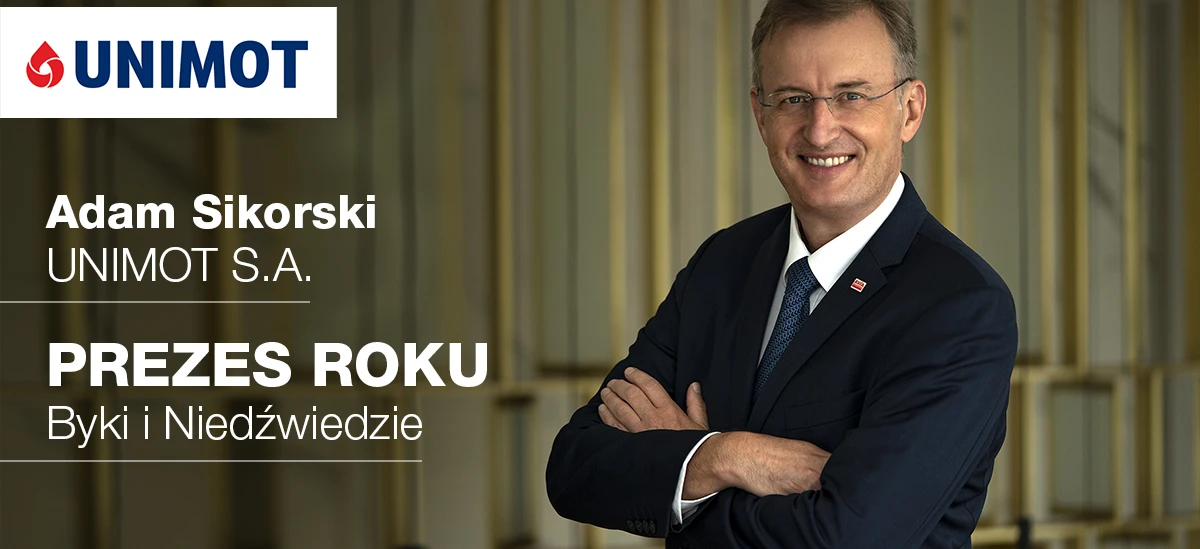 Osoba ubrana w biznesową galanterię, nosząca marynarkę, koszulę i krawat, stoi przed znakiem z polskim tekstem upamiętniającym Adama Sikorskiego z UNIMOT S.A. jako Dyrektora Generalnego roku. Pracownik umysłowy w profesjonalnym stroju.