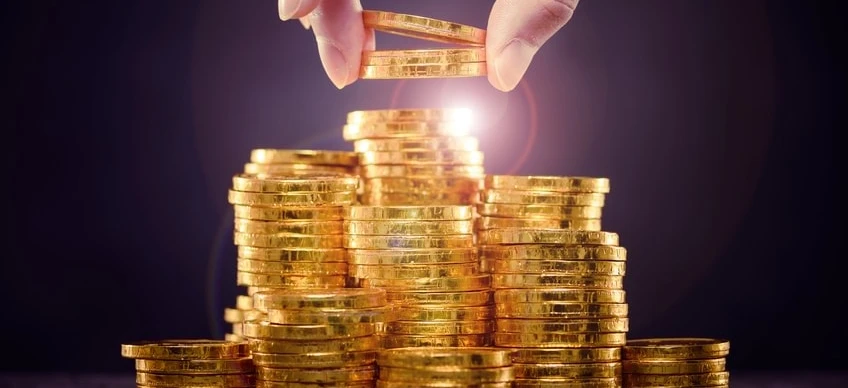 Zbliżenie na złote monety symbolizujące obchodzenie się z pieniędzmi i oszczędzanie. Symbolizujące bogactwo i skarb w walucie.