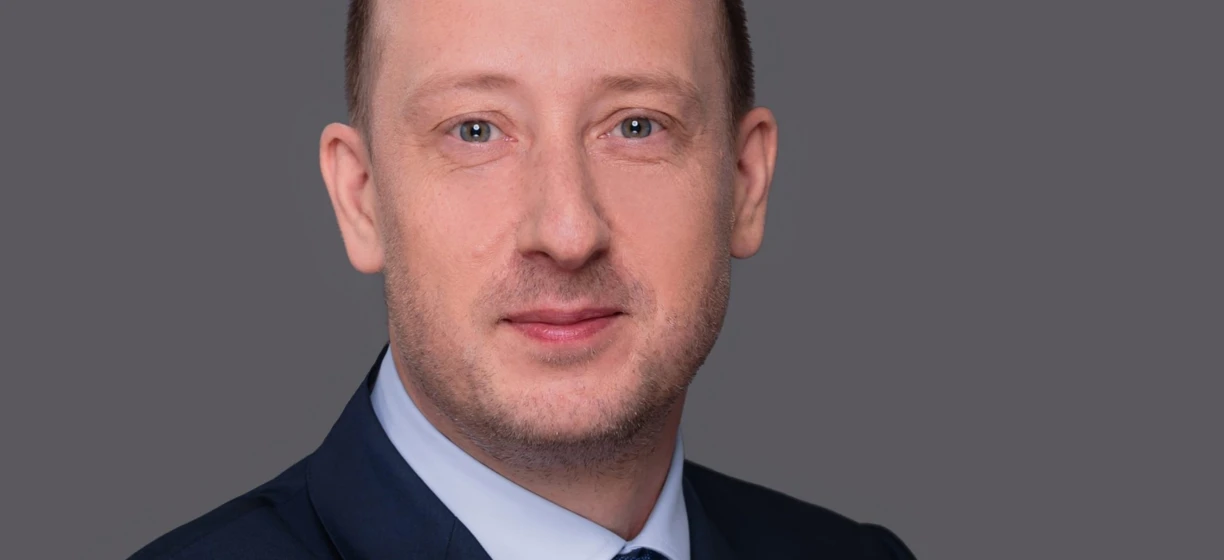 Zblizenie twarzy osoby pokazującej podbródek, policzek, brew, czoło i nos. Ich skóra jest gładka, a linia żuchwy wyraźna. Osoba nosi kołnierz, a ich ramię jest częściowo widoczne.