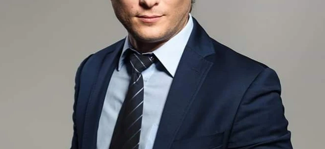 Zblizenie pracownika umyslowego w bialej koszuli, marynarce i krawacie, skupienie na brwiach, czole i kołnierzu.