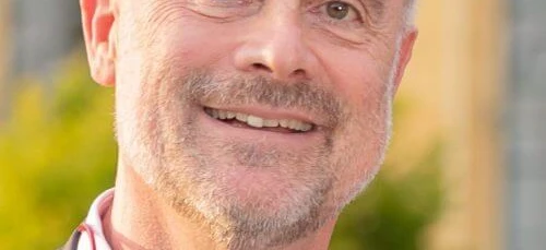 Zblizenie obrazu usmiechnietej twarzy osoby, ukazujacej podbródek, policzek, brwi, czolo i szyje. Osoba wydaje się szczęśliwa, z widocznymi zmarszczkami i gładka skóra.