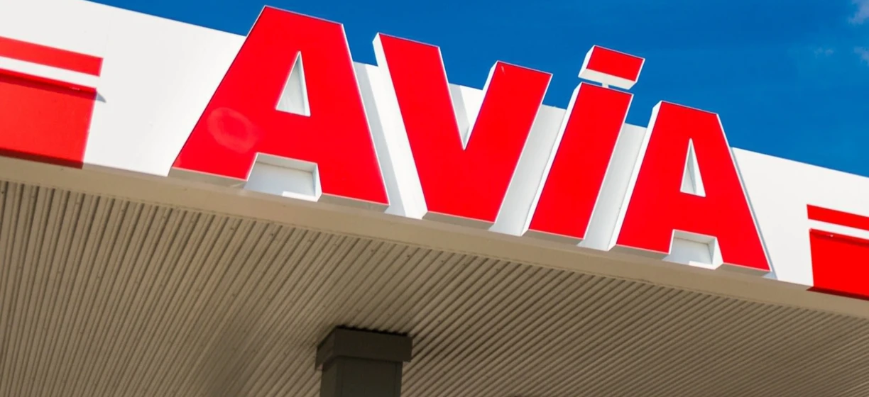 Zbliżenie lusterka wstecznego z odbiciem dystrybutora paliw na stacji benzynowej. Słowa kluczowe: lusterko samochodowe, paliwo, stacja benzynowa, benzyna, AVIA.