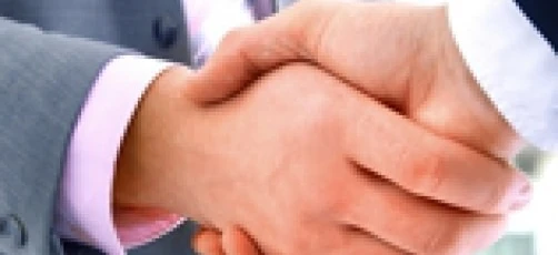 Dwóch pracowników umysłowych witających się uściskając się za ręce w geście współpracy i wzajemnego szacunku. Osoby biznesu nawiązujące kontakty i budujące relacje.