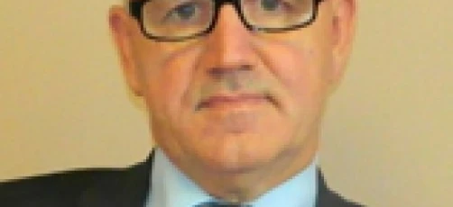 Bliskie zdjęcie osoby noszącej okulary i formalny kołnierzyk. Ich podbródek, brew i czoło są widoczne, razem z żuchwą i szyją.