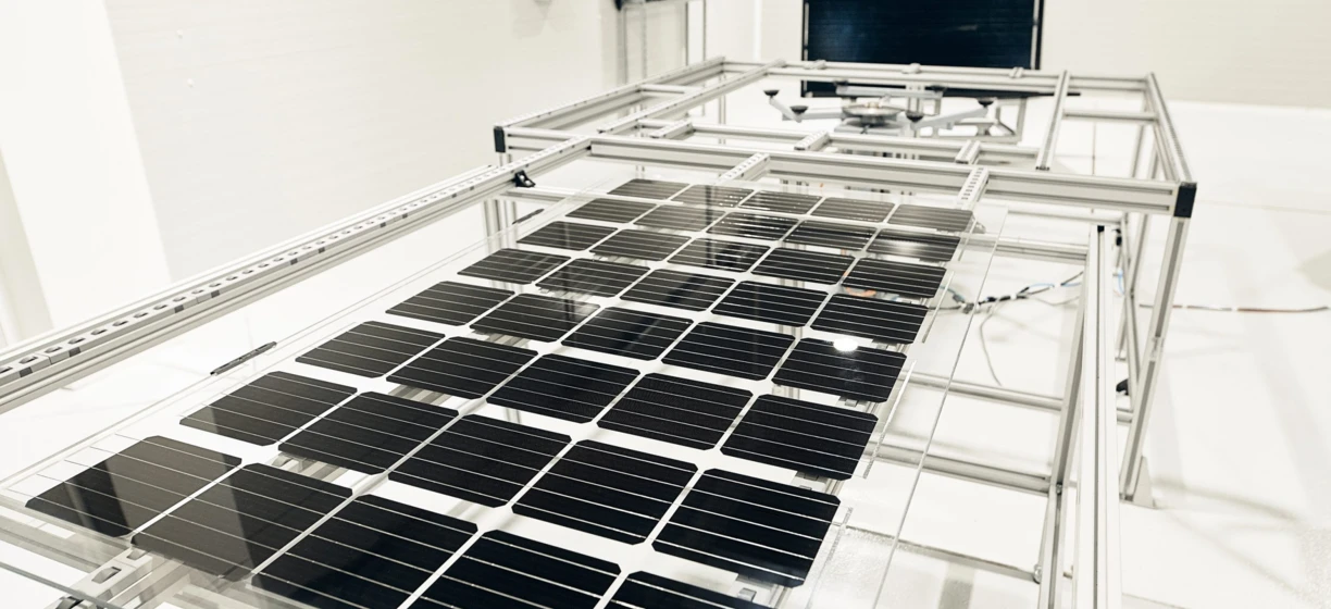 Elegancki, nowoczesny sprzęt wykonujący prace inżynieryjne na komponentach metalowych i stalowych, doskonale ilustrujący precyzję i czystość. Panele słoneczne na drugim planie wskazują na skoncentrowanie się na technologiach zrównoważonej energii.