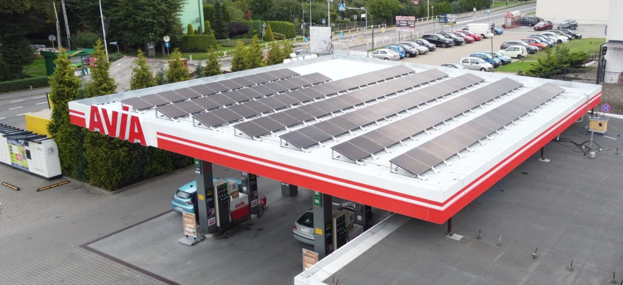 Samochód zaparkowany na stacji benzynowej AVIA z pełnym bakiem paliwa. Tablica rejestracyjna pojazdu widoczna na zdjęciu.