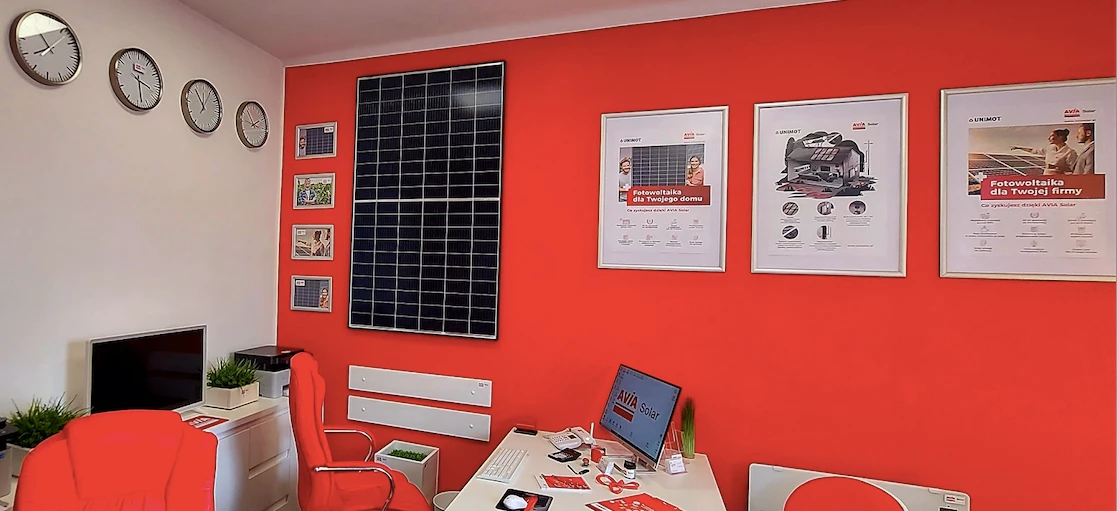 Projekt wnętrza obejmujący meble biurowe, w tym krzesło, biurko i monitor komputerowy. Produkty AVIA Solar oraz UNIMOT do użytku w domu i biurze.
