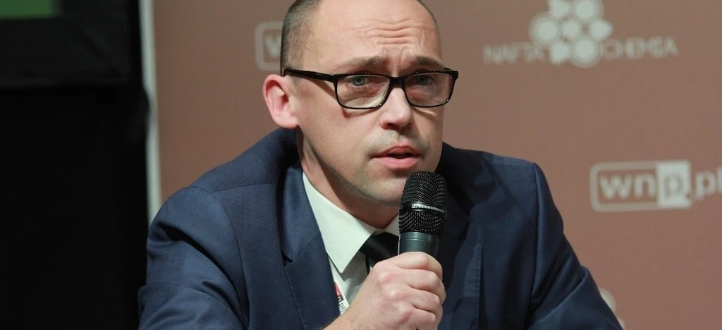 Osoba nosząca okulary i słuchawki, z naciskiem na twarz i brodę. Wyraźnie widoczne logo COCHEMA.