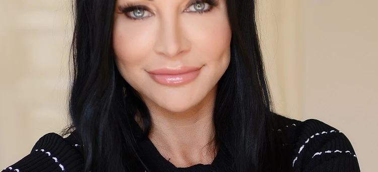 Kobieta o czarnych i długich włosach uśmiecha się, prezentując piękne brwi i usta. Ma oszałamiającą ekspresję twarzy, a stopniowe cięcie i przedłużone rzęsy dodają uroku jej urodzie.