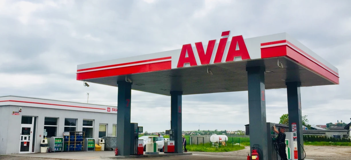 Samochód ciężarowy zaparkowany na stacji paliw z dystrybutorem i lusterkami wstecznymi. Słowa kluczowe: Benzyna, Samochodowy, Ciężarówka, SOLID, AVIA.