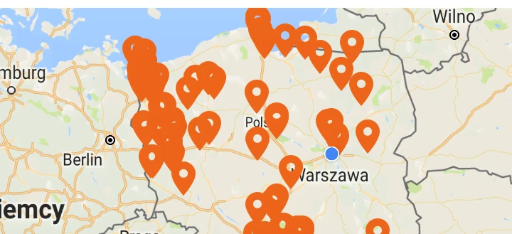 Zrzut ekranu strony internetowej Tankuj24 pokazujący średnie ceny paliwa w okolicy, z mapą stacji benzynowych i numerami wskazującymi oszczędności. Pomarańczowa czcionka i logo M są wyraźnie widoczne.