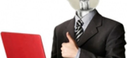 Pracownik umysłowy siedzący przy biurku z urządzeniem elektronicznym i laptopem, otoczony artykułami biurowymi. Słowa kluczowe: Praca, Technologia, Sprzęt komputerowy.