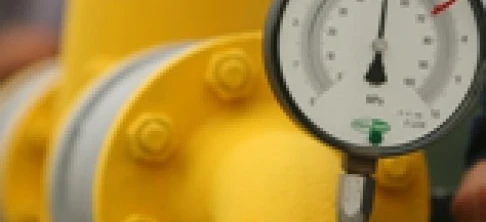 Żółta plastikowa rura z manometrem i zaworem zamocowanym, widoczna na maszynie używanej do pomiarów w instalacjach hydraulicznych.