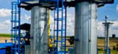 Metalowa stalowa cylinder widziana wewnątrz fabryki, prezentująca inżynierię i produkcję przemysłową. Wykonana z materiałów kompozytowych przechowywanych w metalowym zbiorniku.