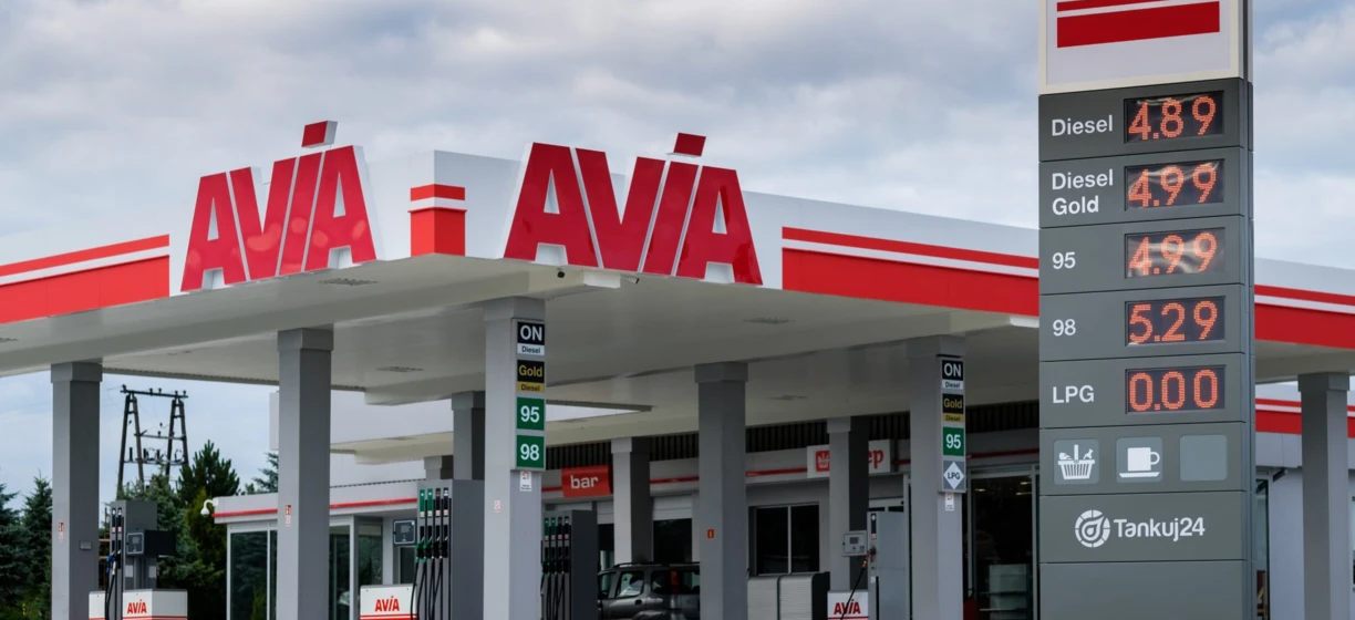 Stacja benzynowa z cenami paliwa wyświetlanymi na cyfrowych ekranach dla oleju napędowego, benzyny Gold i LPG. Słowa kluczowe to AVA, AVIA, FUR, ON, i Tankuj24.
