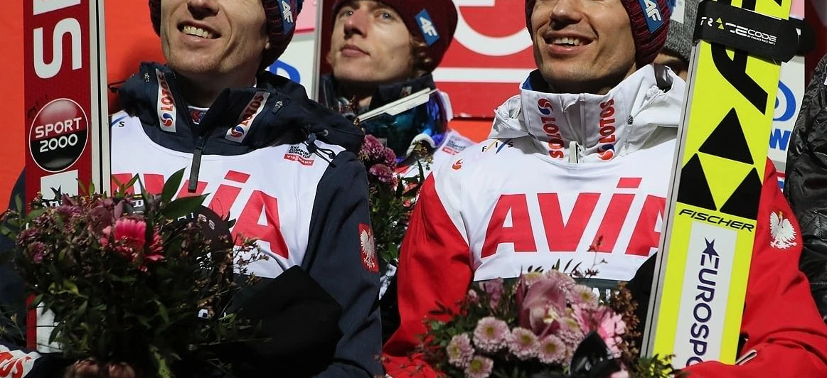 Osoba uśmiecha się podczas uprawiania sportów zimowych na zewnątrz, w śniegu. Przygoda i zabawa czekają w indywidualnym sporcie. #SportyZimowe #RekreacjaNaŚwieżymPowietrzu