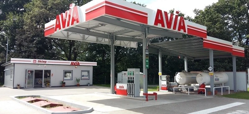 Samochód rodzinny zaparkowany na stacji benzynowej z widoczną tablicą rejestracyjną pojazdu. Słowa kluczowe: paliwo, lusterko samochodowe, sklep.