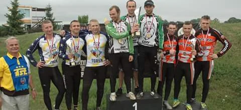 Zespół dumnie stoi na podium w dopasowanych strojach sportowych, świętując swoje mistrzowskie zwycięstwo na zawodach. #Społeczność #Zespół #StrojeSportowe #Mistrzostwo