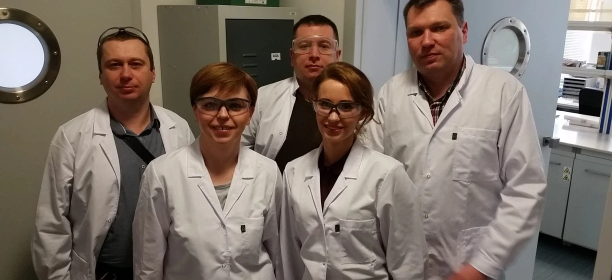 Uśmiechnięty profesjonalista medyczny w białym płaszczu stoi w laboratorium instytutu badawczego, gotowy do udzielenia opieki medycznej. Badacz AGA z grupy Aga Rangemaster.