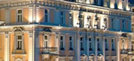 Luksusowy hotel i pałac świecący na tle nocnego nieba w ruchliwej metropolii. Doskonały na wystawny wieczór pod światłami miasta.