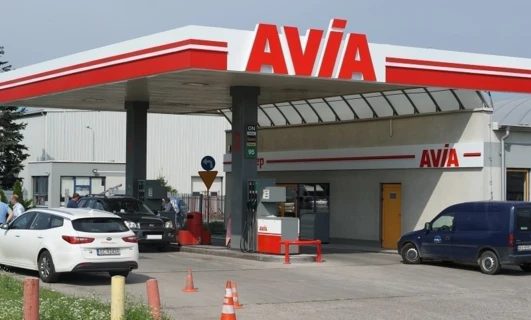 Samochód rodziny zaparkowany na stacji benzynowej z widoczną tablicą rejestracyjną pojazdu "5C92438". Samochód ma złoty zderzak, lusterko samochodowe i boczne lusterko.