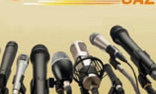 Zespół muzyczny występujący z bębnami i mikrofonami na scenie w UNIMOT GAZ. Muzycy grają różne instrumenty perkusyjne podczas występu na żywo.