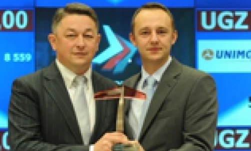 Uśmiechnięty pracownik biurowy w formalnym ubraniu z logo na koszuli, reprezentujący profesjonalizm i satysfakcję z pracy. 

Słowa kluczowe: Formalne ubranie, Garnitur, Marynarka, Płaszcz, Pracownik biurowy, Krawat, Koszula do garnituru, Uśmiech, Praca, Logo.