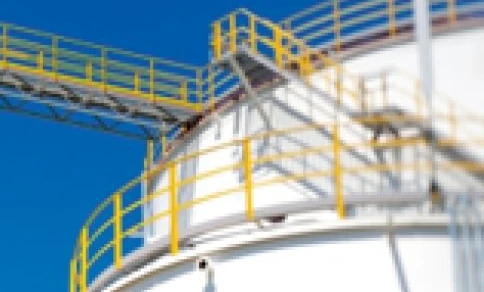 Zbiornik na metal w fabryce przemysłowej, wykonany z materiału kompozytowego i stalowych cylindrów. Inżynieria ekspertów dla efektywnych rozwiązań magazynowania.