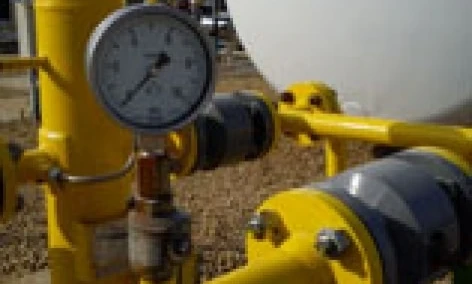 Maszyna przemysłowa z rurą, cylindrem i zbiornikiem magazynowym z zaworami i armaturą hydraulikną wykonaną ze stali. Wykonywane są pomiary na urządzeniu.