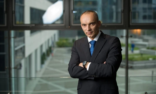 Pracownik umysłowy pewnie stojący w garniturze z marynarką i krawatem. Klasyczny i profesjonalny strój na sukces w biznesie.