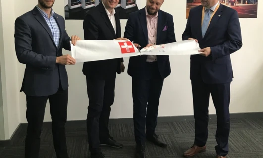 Mężczyzna w garniturze w formalnym ubraniu, stojący i uśmiechający się. Idealny dla pracownika umysłowego. Ubranie marki AVIA w Szanghaju.