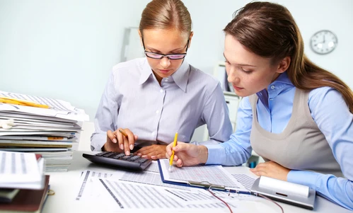 Zagracany biurko z artykułami biurowymi i papierem, symbolizujący zabiegane stanowisko pracy lub środowisko nauki studenta. Przestrzeń do pracy białego kołnierza lub studenta.