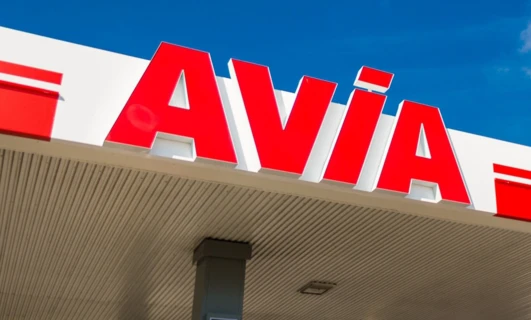 Zbliżenie lusterka wstecznego z odbiciem dystrybutora paliw na stacji benzynowej. Słowa kluczowe: lusterko samochodowe, paliwo, stacja benzynowa, benzyna, AVIA.