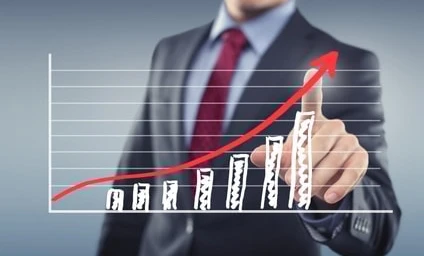 Pracownik biurowy w eleganckim ubraniu gestykulujący kciukiem, reprezentujący zarządzanie lub handel w ustawieniach biznesowych.