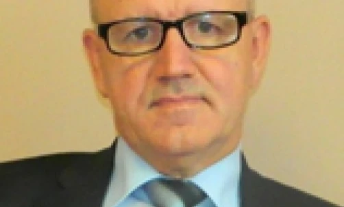 Bliskie zdjęcie osoby noszącej okulary i formalny kołnierzyk. Ich podbródek, brew i czoło są widoczne, razem z żuchwą i szyją.