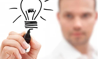 Osoba prowadząca firmę z radością trzymająca żarówkę, symbolizująca innowację w nowoczesnym biurze. Gest sukcesu w schludnej przestrzeni pracy.