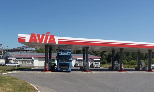 Ciężarówka dostawcza tankuje na stacji benzynowej przy autostradzie przy użyciu dystrybutora paliwa NATANEK. Benzyna jest pompowana do pojazdu.