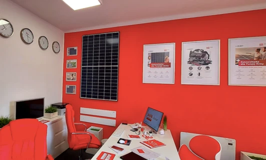 Projekt wnętrza obejmujący meble biurowe, w tym krzesło, biurko i monitor komputerowy. Produkty AVIA Solar oraz UNIMOT do użytku w domu i biurze.